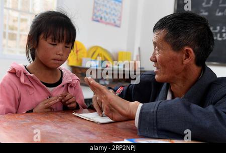 (180908) -- KUNMING, 8 septembre 2018 -- Wang Zhengxiang (à droite) enseigne à un élève de l'école primaire Ayiyang dans le village de Sanmeng, dans le comté autonome de Luquan Yi et Miao, dans le sud-ouest de la Chine, province du Yunnan, 6 septembre 2018. Un enseignant, huit étudiants, aucun n’a été et ne sera abandonné grâce à l’enseignant rural Wang Zhengxiang. Wang Zhengxiang du groupe ethnique Miao, 56 ans, est le seul enseignant et enseigne à l'école primaire du village isolé d'Ayiyang depuis 38 ans. L’école primaire d’Ayiyang, située à une altitude de 2 600 mètres au-dessus du niveau de la mer et entourée de montagnes, n’est pas facilement accessible de l’extérieur Banque D'Images