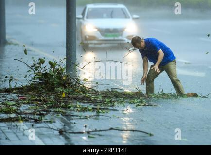 (180916) -- SHENZHEN, 16 septembre 2018 -- Un membre du personnel nettoie les égouts bloqués sur une route du district de Nanshan à Shenzhen, dans la province du Guangdong du sud de la Chine, 16 septembre 2018. Selon le Centre météorologique national de la Chine, Mangkhut devrait atterrir dans le Guangdong entre dimanche après-midi et soir. (Yxb) CHINA-GUANGDONG-TYPHOON MANGKHUT (CN) MaoxSiqian PUBLICATIONxNOTxINxCHN Banque D'Images