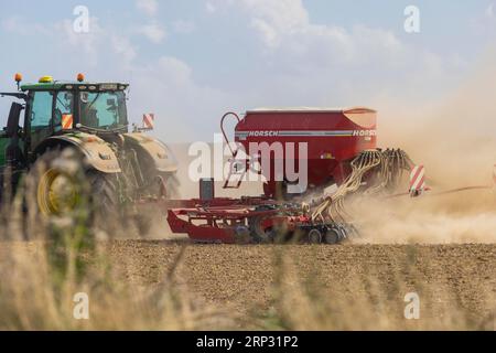 Un tracteur avec un semoir Horsch PRONTO DC 6 semant dans un champ sec à la fin de l'été., Doma, Saxe, Allemagne Banque D'Images