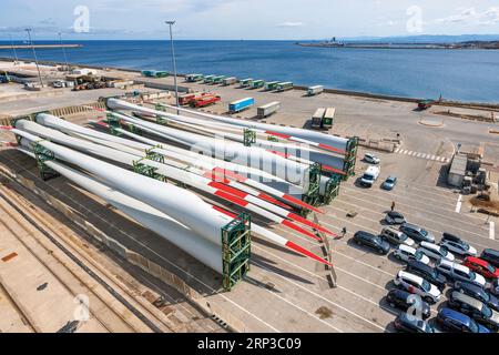Porto Torres, Sardaigne, Italie. Zone industrielle. Wagons et pales de rotor d'éolienne en attente de chargement sur le navire. Banque D'Images