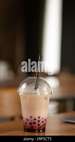 Thé au lait thaïlandais avec des bulles dans le café restaurant sur la table sur fond intérieur Banque D'Images