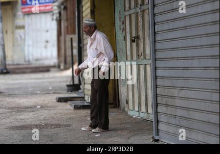 (181001) -- NAPLOUSE, 1 octobre 2018 -- Un palestinien se tient devant un magasin fermé dans une rue vide de la ville de Naplouse en Cisjordanie, le 1 octobre 2018. Les territoires palestiniens en Cisjordanie, dans la bande de Gaza et dans les villes palestiniennes en Israël ont connu lundi une grève générale pour protester contre la loi sur l’État-nation juif récemment adoptée en Israël. )(rh) MIDEAST-NAPLOUSE-GENERAL-STRIKE KhaledxOmar PUBLICATIONxNOTxINxCHN Banque D'Images