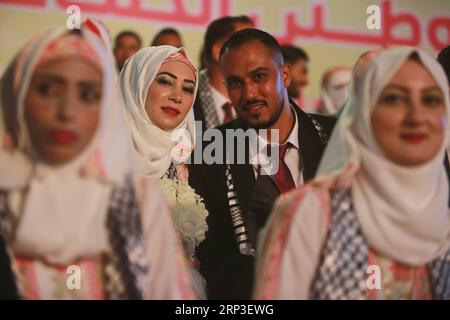 (181003) -- GAZA, 3 octobre 2018 () -- Un couple palestinien participe à un mariage de masse dans la ville de Gaza, le 2 octobre 2018. Au total, 360 mariés ont été submergés de joie mardi lors d’une cérémonie de mariage de masse, parrainée par le président palestinien Mahmoud Abbas. (/Stringer)(dh) MIDEAST-GAZA-MASS WEDDING Xinhua PUBLICATIONxNOTxINxCHN Banque D'Images