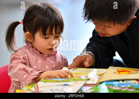 (181006) -- TAIYUAN, 6 octobre 2018 -- Une petite fille lit un livre à la bibliothèque du Shanxi à Taiyuan, capitale de la province du Shanxi du nord de la Chine, le 6 octobre 2018, à l'occasion des vacances de la fête nationale d'une semaine à partir du 1 octobre.) (Ry) CHINA-SHANXI-LIBRARY-HOLIDAY (CN) CaoxYang PUBLICATIONxNOTxINxCHN Banque D'Images