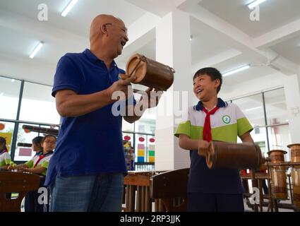 (181008) -- NANCHANG, 8 octobre 2018 -- un membre d'un groupe local de musique en bambou enseigne à un élève à jouer d'un instrument de musique en bambou dans le comté de Chongyi, dans la province de Jiangxi, dans l'est de la Chine, le 8 octobre 2018. Les membres de l'orchestre de musique en bambou sont invités régulièrement dans une école primaire pour donner des cours aux élèves sur des instruments de musique en bambou. (Gxn) CHINA-JIANGXI-CHONGYI-BAMBOO INSTRUMENT (CN) HuxChenhuan PUBLICATIONxNOTxINxCHN Banque D'Images