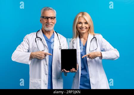 Médecins seniors montrant tablette numérique, grande application mobile pour la télémédecine Banque D'Images