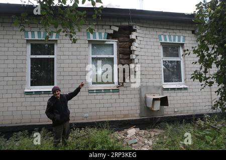 (181009) -- ICHNYA (UKRAINE), 9 octobre 2018 -- Un résident se tient devant une maison endommagée par l'explosion d'un dépôt de munitions près d'Ichnya, Tchernigov, Ukraine, le 9 octobre 2018. Plus de 12 500 personnes ont été évacuées mardi à la suite de l incendie et des explosions dans un dépôt de munitions de l armée ukrainienne dans la région nord de Tchernigov, ont indiqué les autorités. UKRAINE-ICHNYA-DEPOT DE MUNITIONS-EXPLOSIONS Sergey PUBLICATIONxNOTxINxCHN Banque D'Images