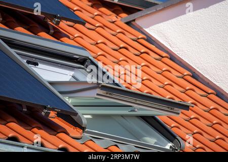 Toit ouvrant sur un nouveau toit en tuiles avec capteurs solaires Banque D'Images