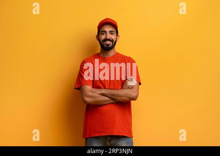 Service de messagerie. Portrait d'un livreur indien joyeux portant un uniforme rouge Banque D'Images