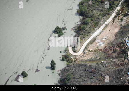 (181018) -- NYINGCHI, 18 octobre 2018 (Xinhua) -- une photo aérienne prise le 18 octobre 2018 montre une route partiellement submergée par le lac barrière causé par le glissement de terrain sur la rivière Yarlung Tsangpo dans le comté de Menling, dans la région autonome du Tibet du sud-ouest de la Chine. Plus de 6 000 personnes ont été évacuées après la formation d'un lac barrière suite à un glissement de terrain dans la rivière Yarlung Tsangpo, dans la région autonome du Tibet du sud-ouest de la Chine, ont déclaré jeudi les autorités locales. Selon le siège local des secours en cas de catastrophe, le glissement de terrain a frappé au petit matin de mercredi près d'un village dans le comté de Menling, bloquant t Banque D'Images