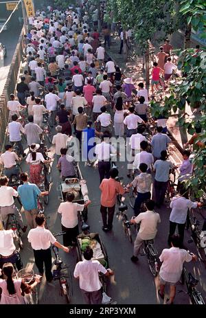 (181020) -- BEIJING, 20 octobre 2018 -- des gens font du vélo à travers un passage à Zhengzhou, dans la province du Henan, au centre de la Chine, en juin 1988. Si vous veniez à Pékin, capitale de la Chine, il y a 40 ans, vous avez probablement été frappé par la mer des vélos dans les rues, un phénomène unique qui a valu à la Chine le titre de royaume des vélos. À cette époque, les Chinois ordinaires ne pouvaient pas se permettre de voitures et peu de gens pouvaient voyager par avion, sans parler des voyages fréquents sur de longues distances. Les trains, le moyen de transport le plus courant à l'époque, étaient toujours bourrés dans les compartiments étouffants. Cependant, les roues du changement avaient commencé Banque D'Images