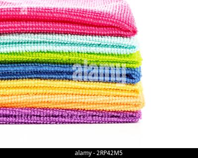 Pile de serviettes de cuisine en microfibre dans des couleurs vives sur un fond blanc.Close up Banque D'Images