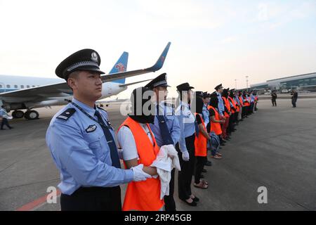 (181027) -- GUANGZHOU, le 27 octobre 2018 -- les suspects de crime économique sont escortés pour arriver à l'aéroport international Baiyun de Guangzhou, capitale de la province du Guangdong du sud de la Chine, le 26 octobre 2018. Dix-sept fugitifs soupçonnés de collecte de fonds illégale via des plateformes de prêt en ligne sont retournés vendredi à Guangzhou depuis la Thaïlande. Depuis juin, un certain nombre de cadres supérieurs qui gèrent des plateformes illégales de prêt peer-to-peer en ligne ont fui à l’étranger en raison d’une crise de capitaux. Le Ministère de la sécurité publique a donc dépêché des unités de travail spécialisées à l ' étranger pour arrêter ces personnes soupçonnées de crimes économiques.) ( Banque D'Images