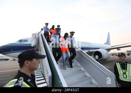 (181027) -- GUANGZHOU, le 27 octobre 2018 -- les suspects de crime économique sont escortés pour arriver à l'aéroport international Baiyun de Guangzhou, capitale de la province du Guangdong du sud de la Chine, le 26 octobre 2018. Dix-sept fugitifs soupçonnés de collecte de fonds illégale via des plateformes de prêt en ligne sont retournés vendredi à Guangzhou depuis la Thaïlande. Depuis juin, un certain nombre de cadres supérieurs qui gèrent des plateformes illégales de prêt peer-to-peer en ligne ont fui à l’étranger en raison d’une crise de capitaux. Le Ministère de la sécurité publique a donc dépêché des unités de travail spécialisées à l ' étranger pour arrêter ces personnes soupçonnées de crimes économiques.) ( Banque D'Images