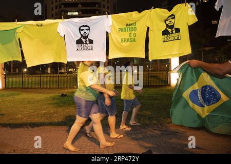 (181029) -- RIO DE JANEIRO, le 29 octobre 2018 -- les partisans de Jair Bolsonaro passent devant des T-shirts avec son portrait à Rio de Janeiro, Brésil, le 28 octobre 2018. Le candidat de droite du Brésil, Jair Bolsonaro, du Parti social-libéral, a remporté le deuxième tour du scrutin présidentiel dimanche, selon la Cour électorale supérieure du Brésil (TSE). (psw) BRÉSIL-RIO DE JANEIRO-RÉSULTATS DE L'ÉLECTION PRÉSIDENTIELLE LixMing PUBLICATIONxNOTxINxCHN Banque D'Images