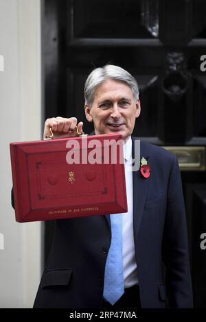 (181029) -- LONDRES, le 29 octobre 2018 -- le chancelier de l'Échiquier britannique Philip Hammond pose avec la boîte budgétaire devant le 11 Downing Street avant de présenter le troisième budget à Londres, en Grande-Bretagne, le 29 octobre 2018. Philip Hammond a présenté son troisième budget et le dernier avant la date prévue du Brexit avec une promesse de mettre en œuvre les politiques révélées, indépendamment de l'existence ou non d'un accord sur le Brexit. ROYAUME-UNI-LONDRES-CHANCELIER D'EXCHEQUER-TROISIÈME BUDGET STEPHENXCHUNG PUBLICATIONXNOTXINXCHN Banque D'Images