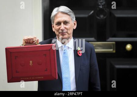 (181029) -- LONDRES, le 29 octobre 2018 -- le chancelier de l'Échiquier britannique Philip Hammond pose avec la boîte budgétaire devant le 11 Downing Street avant de présenter le troisième budget à Londres, en Grande-Bretagne, le 29 octobre 2018. Philip Hammond a présenté son troisième budget et le dernier avant la date prévue du Brexit avec une promesse de mettre en œuvre les politiques révélées, indépendamment de l'existence ou non d'un accord sur le Brexit. ROYAUME-UNI-LONDRES-CHANCELIER D'EXCHEQUER-TROISIÈME BUDGET STEPHENXCHUNG PUBLICATIONXNOTXINXCHN Banque D'Images