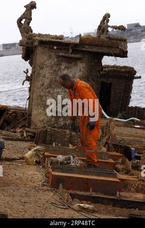(181031) -- PERAMA, le 31 octobre 2018 -- un ouvrier enlève les débris du naufrage de l'île de Corfou dans la zone de réparation de Perama, en Grèce, le 30 octobre 2018. Trente-deux ans après son naufrage sur le quai II de la zone de réparation navale de Perama, l'île de Corfou a été récupérée cet automne. La levée et le remorquage de l'épave du ferry appartenant à la Grèce est la première étape d'un projet plus vaste lancé par les autorités grecques pour nettoyer les eaux du golfe Saronique de dizaines de tels naufrages, ont déclaré mardi les responsables ici. GRÈCE-NAUFRAGE-RÉCUPÉRATION MariosxLolos PUBLICATIONxNOTxINxCHN Banque D'Images