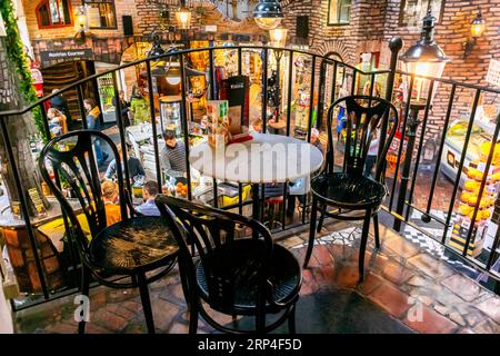 Vienne, Autriche, vue sur la table traditionnelle du café, chaises sur le balcon donnant sur les personnes en petit groupe partageant des boissons à l'intérieur du café viennois, bar, Huntertwasserhaus (architecte : Josef KRAWINA) Banque D'Images