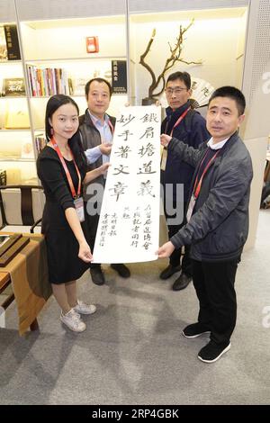 (181108) -- SHANGHAI, 8 novembre 2018 -- Yan Weiqi (1e L), journaliste au Guangming Daily, présente son travail de calligraphie au centre des médias de la première China International Import Expo (CIIE) à Shanghai, dans l'est de la Chine, le 8 novembre 2018. Diverses activités ont été organisées pour saluer la 19e Journée des journalistes en Chine. ) (Zyd) (IMPORT EXPO) CHINA-SHANGHAI-CIIE-JOURNALISTS DAY (CN) ShenxBohan PUBLICATIONxNOTxINxCHN Banque D'Images