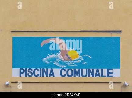 Panneau mosaïque de la piscine municipale ('piscina comunale' en italien) sur l'extérieur du bâtiment de la piscine olympique 'Carlo Zanelli', Savone, Italie Banque D'Images