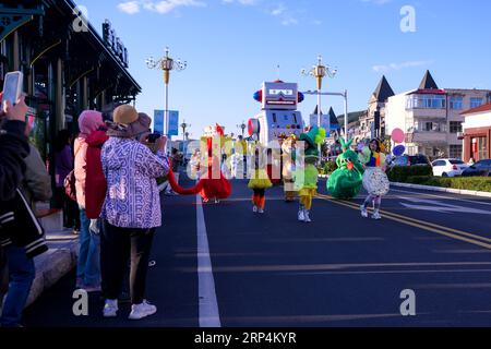 (230903) -- ARXAN, 3 septembre 2023 (Xinhua) -- des touristes regardent un défilé de flotteurs au centre-ville d'Arxan, dans la Ligue Hinggan, dans la région autonome de Mongolie intérieure du nord de la Chine, le 1 septembre 2023. Arxan, situé au pied sud-ouest des montagnes Dahinggan et à l'intersection de quatre grandes prairies, est une destination touristique de plus en plus populaire. Le marché du tourisme en Mongolie intérieure est en plein essor en 2023. De janvier à juillet, la région a reçu 124 millions de touristes nationaux, réalisant des recettes touristiques record de 176,22 milliards de yuans (24,48 milliards de dollars américains). (Xinhua/Li Zhipeng) Banque D'Images