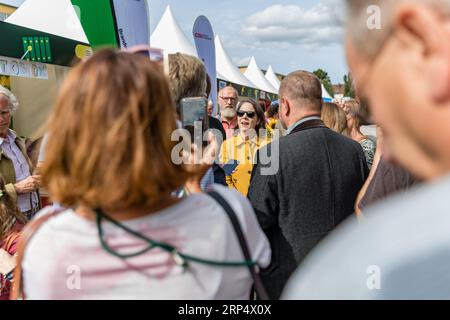 Finsterwalde, Allemagne. 03 septembre 2023. Annalena Baerbock (Bündnis 90/Die Grünen), ministre des Affaires étrangères, est entourée de visiteurs lors de la Journée du Brandebourg. Sous la devise «ici la musique joue», la première Journée Brandebourg après 2018 aura lieu ce week-end à Finsterwalde, une ville de 17 000 habitants. Crédit : Frank Hammerschmidt/dpa/Alamy Live News Banque D'Images