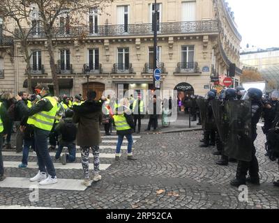 (181124) -- PARIS, 24 novembre 2018 -- des manifestants gilets jaunes affrontent la police sur l'avenue des champs-Elysées à Paris, France, le 24 novembre 2018. Pendant une semaine, les manifestants gilets jaunes ont bloqué les autoroutes à travers les villes françaises avec des barricades enflammées et des camions lents, obstruant l'accès aux dépôts de carburant, aux centres commerciaux et à certaines usines. )(mcg) FRANCE-PARIS-GILET JAUNE PROTESTATIONS HanxBing PUBLICATIONxNOTxINxCHN Banque D'Images