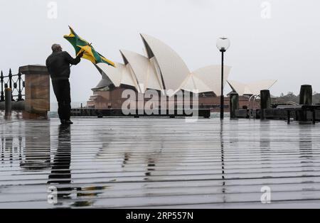 (181128) -- SYDNEY, 28 novembre 2018 -- Un homme passe devant l'Opéra de Sydney sous la pluie à Sydney, Australie, le 28 novembre 2018. La ville a rencontré des vents forts et de fortes pluies mercredi. ) (YY) AUSTRALIE-SYDNEY-MÉTÉO-TEMPÊTE BaixXuefei PUBLICATIONxNOTxINxCHN Banque D'Images