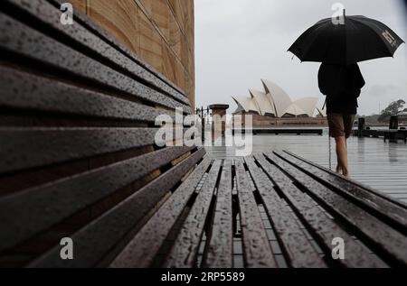 (181128) -- SYDNEY, 28 novembre 2018 -- Un homme marche vers l'Opéra de Sydney sous la pluie à Sydney, Australie, 28 novembre 2018. La ville a rencontré des vents forts et de fortes pluies mercredi. ) (YY) AUSTRALIE-SYDNEY-MÉTÉO-TEMPÊTE BaixXuefei PUBLICATIONxNOTxINxCHN Banque D'Images