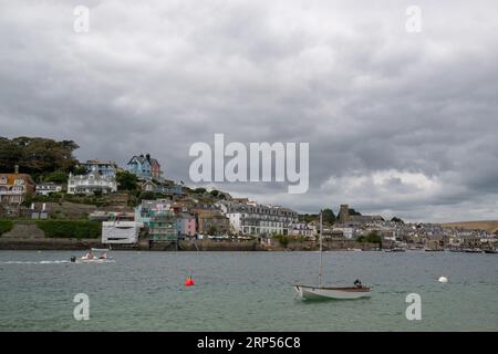 Vue de la ville de Salcombe prise de l'autre côté du port de East Portlemouth avec une eau calme et un ciel sombre avec canot au premier plan. Banque D'Images