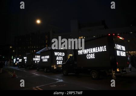 (181202) -- NEW YORK, 2 décembre 2018 -- Une flotte de cinq camions arborant des panneaux LED est vue dans un mémorial de la Journée mondiale du sida à New York, aux États-Unis, le 1 décembre 2018. Le mémorial présentant une expérience lumineuse interactive a eu lieu samedi dans le Lower Manhattan, marquant la Journée mondiale du sida et honorant les victimes de cette maladie mortelle. Plus de 200 personnes se sont rassemblées au New York City AIDS Memorial Park pour l'événement LightTheFight. Tenant des bâtons lumineux verts, ils ont chanté des chansons et observé un moment de silence pour les plus de 100 000 personnes qui sont mortes du sida dans la ville et les dizaines de milli Banque D'Images