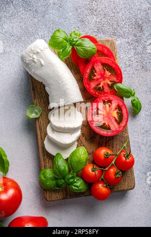 Salade de capres avec mozzarella, tomates en tranches, épices et basilic frais. Des aliments faits maison. Concept pour un repas savoureux et sain. Banque D'Images