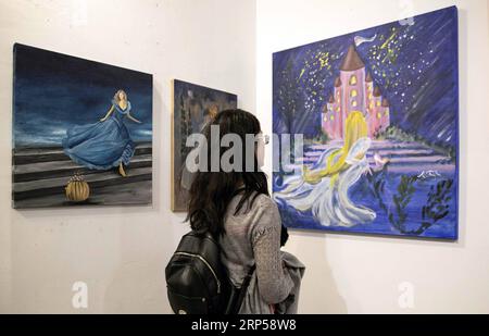 (181204) -- ATHÈNES, 4 décembre 2018 -- la photo prise le 3 décembre 2018 montre une femme regardant un tableau lors de l'événement artistique Cendrillon Goes Art à Athènes, Grèce. Les bénéfices du gala seront reversés à une fondation pour les enfants ayant des handicaps multiples. (YY) GREECE-ATHENS-CINDERELLA-ART LefterisxPartsalis PUBLICATIONxNOTxINxCHN Banque D'Images