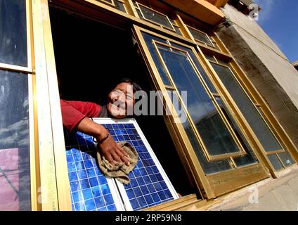 (181205) -- BEIJING, 5 déc. 2018 () -- une femme nettoie un panneau solaire dans sa nouvelle maison grâce au projet Guangming, qui a été lancé par le gouvernement chinois en 1997 pour résoudre le problème de l'approvisionnement en électricité des régions sans électricité en développant une nouvelle production d'électricité, dans la région autonome du Tibet du sud-ouest de la Chine, 12 octobre 2006. La Chine a tenu son engagement envers la communauté internationale en matière de changement climatique en passant constamment à une économie plus verte ces dernières années. De nouvelles régions riches en énergie comme la Mongolie intérieure et le Ningxia envoient plus d’électricité produite à partir de sources propres Banque D'Images