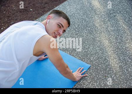 Gros plan d'un jeune homme caucasien faisant des pompes sur son tapis de sport. Copier l'espace sur la droite Banque D'Images