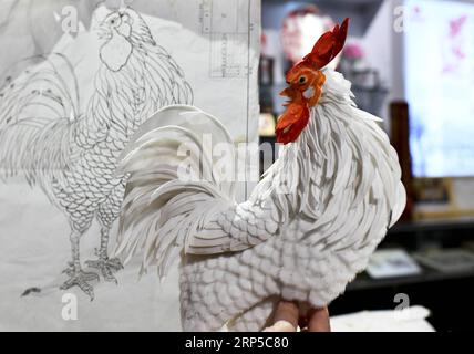 (181208) -- ZUNYI, 8 déc. 2018 (Xinhua) -- Zuo Huiping, héritier représentatif de la technique de fabrication d'œuvres d'art d'usine de papier de riz, compare une œuvre avec son croquis à Zunyi, dans la province du Guizhou du sud-ouest de la Chine, le 8 décembre 2018. La plante de papier de riz (tetrapanax papyrifer) est un arbuste à feuilles persistantes utilisé dans la médecine traditionnelle chinoise. La technique de fabrication d'œuvres d'art d'usine de riz-papier a été répertoriée comme l'un des deuxième lots de patrimoines culturels immatériels provinciaux au Guizhou. (Xinhua/Luo Xinghan) (gxn) CHINE-GUIZHOU-ZUNYI-TCM-ARTISANAT (CN) PUBLICATIONxNOTxINxCHN Banque D'Images