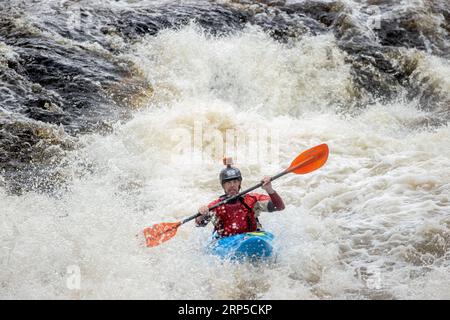 Un concurrent prenant les rapides sur la rivière Raquette à l'extérieur de Colton, NY dans le cadre de la Whitewater Monarch of New York Race Series Banque D'Images