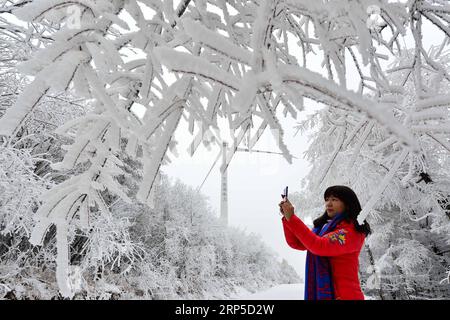 (181209) -- XIANGYANG, 9 déc. 2018 (Xinhua) -- un visiteur prend des photos de paysages rime à Hengchong dans la ville de Houping sous le comté de Baokang, province du Hubei en Chine centrale, 8 déc. 2018 (Xinhua/Yang Tao)(mp) CHINA-HUBEI-BAOKANG COUNTY-SNOW (CN) PUBLICATIONxNOTxINxCHN Banque D'Images
