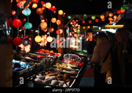 (181212) -- BRUXELLES, 12 décembre 2018 -- des gens passent devant un magasin vendant des lumières colorées sur un marché de Noël dans le centre de Bruxelles, Belgique, le 12 décembre 2018. Plus de 200 chalets et attractions de foire au marché de Noël attirent les visiteurs ici pendant la saison des fêtes.) BELGIQUE-BRUXELLES-MARCHÉ DE NOËL ZhengxHuansong PUBLICATIONxNOTxINxCHN Banque D'Images