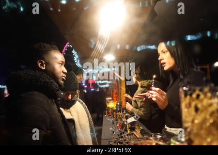 (181212) -- BRUXELLES, le 12 décembre 2018 -- Un commerçant (R) discute avec un client à un marché de Noël dans le centre de Bruxelles, Belgique, le 12 décembre 2018. Plus de 200 chalets et attractions de foire au marché de Noël attirent les visiteurs ici pendant la saison des fêtes.) BELGIQUE-BRUXELLES-MARCHÉ DE NOËL ZhengxHuansong PUBLICATIONxNOTxINxCHN Banque D'Images