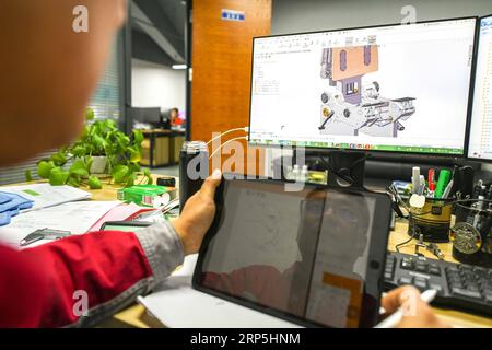 (181215) -- HARBIN, 15 décembre 2018 -- Fu Qiang examine un plan de cockpit de simulateur de vol chez Wright Brothers Science and Technology Development Co., Ltd. À Harbin, dans la province du Heilongjiang du nord-est de la Chine, le 14 décembre 2018. Sans un engouement commun pour la simulation de vol, il y a de fortes chances que Liu Zhongliang, Fu Qiang et Zhou Zhiyuan, qui avaient autrefois mené trois carrières entièrement distinctes, ne se croisent jamais, et encore moins s'associent pour aborder un rêve aéronautique. Le trio passionné d'aviation a lancé son équipe de développement de matériel en 2009. Dès le premier circuit électronique Banque D'Images