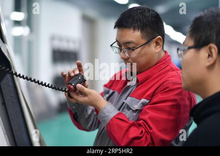 (181215) -- HARBIN, 15 décembre 2018 -- Fu Qiang (à gauche) examine une pièce de cockpit de simulateur de vol chez Wright Brothers Science and Technology Development Co., Ltd. À Harbin, dans la province du Heilongjiang du nord-est de la Chine, le 14 décembre 2018. Sans un engouement commun pour la simulation de vol, il y a de fortes chances que Liu Zhongliang, Fu Qiang et Zhou Zhiyuan, qui avaient autrefois mené trois carrières entièrement distinctes, ne se croisent jamais, et encore moins s'associent pour aborder un rêve aéronautique. Le trio passionné d'aviation a lancé son équipe de développement de matériel en 2009. Dès le premier circuit électronique, Banque D'Images