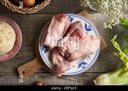 Viande de poulet congelée et légumes frais - Ingrédients pour bouillon d'os ou soupe sur une table rustique Banque D'Images