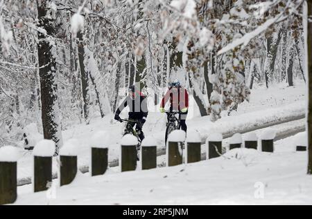 (181216) -- BELGRADE, 16 déc. 2018 -- deux hommes font du vélo sur une route enneigée à Belgrade, Serbie, le 16 décembre 2018.) SERBIE-BELGRADE-MÉTÉO-NEIGE PredragxMilosavljevic PUBLICATIONxNOTxINxCHN Banque D'Images