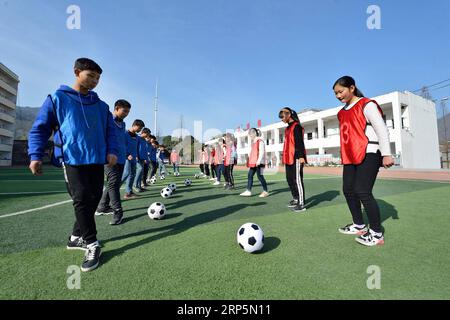 (181219) -- XIANGYANG, 19 déc. 2018 (Xinhua) -- des élèves pratiquent le soccer à l'école centrale de Xiema Town, dans le canton de Xiema, dans le comté de Baokang, dans la province du Hubei en Chine centrale, 18 déc. 2018. Xiema Town Central School, un internat rural situé dans une région montagneuse reculée de la province du Hubei, est la première école pilote de football à Baokang. L'école a construit un terrain de football en 2015, et a ajouté le football à son programme, offrant aux étudiants un accès à plus de chances de jouer au football, ainsi qu'aider les jeunes footballeurs à poursuivre leurs rêves. (Xinhua/Yang Tao) CHINA-HUBEI-RURAL-SOCC Banque D'Images