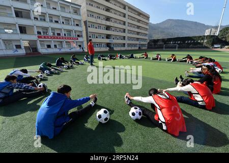 (181219) -- XIANGYANG, 19 déc. 2018 (Xinhua) -- des élèves grimpent dans une classe de football à l'école centrale de Xiema Town, dans le canton de Xiema, dans le comté de Baokang, dans la province du Hubei en Chine centrale, 18 déc. 2018. Xiema Town Central School, un internat rural situé dans une région montagneuse reculée de la province du Hubei, est la première école pilote de football à Baokang. L'école a construit un terrain de football en 2015, et a ajouté le football à son programme, offrant aux étudiants un accès à plus de chances de jouer au football, ainsi qu'aider les jeunes footballeurs à poursuivre leurs rêves. (Xinhua/Yang Tao) CHINE-HUBEI-RURAL Banque D'Images