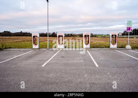 Greåker, Norvège - novembre 19 2022 : rangée de Superchargeurs Tesla près d'un champ Banque D'Images