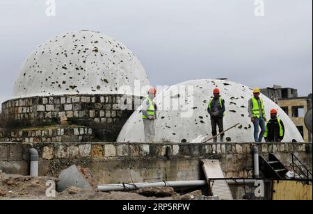 (181222) -- ALEP (SYRIE), 22 décembre 2018 -- des travailleurs syriens se tiennent sur le toit du souk couvert al-Saqatiyya à Alep, dans le nord de la Syrie, le 19 décembre 2018. Dans la ville d Alep, au nord de la Syrie, la détermination des habitants à reconstruire leur vie et leur ville est plus forte que la destruction massive qui les a frappés. Deux ans après sa libération, les gens ont déjà retroussé leurs manches et commencé à réparer la destruction dans l'ancien marché fortifié de la ville, pas découragé par la dévastation.) SYRIE-ALEP-RESTAURATION AmmarxSafarjalani PUBLICATIONxNOTxINxCHN Banque D'Images