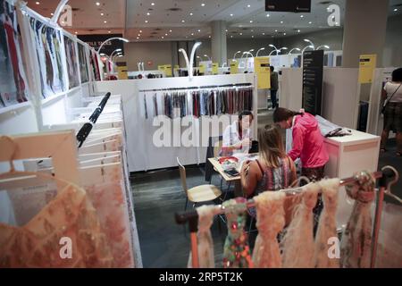 (181223) -- NEW YORK, le 23 décembre 2018 -- les acheteurs examinent des échantillons d'un producteur chinois de tissus au salon chinois du textile et du vêtement 2018 à New York, aux États-Unis, le 23 juillet 2018. ) Xinhua Headlines : une entreprise de mode américaine lutte contre l'incertitude tarifaire WangxYing PUBLICATIONxNOTxINxCHN Banque D'Images